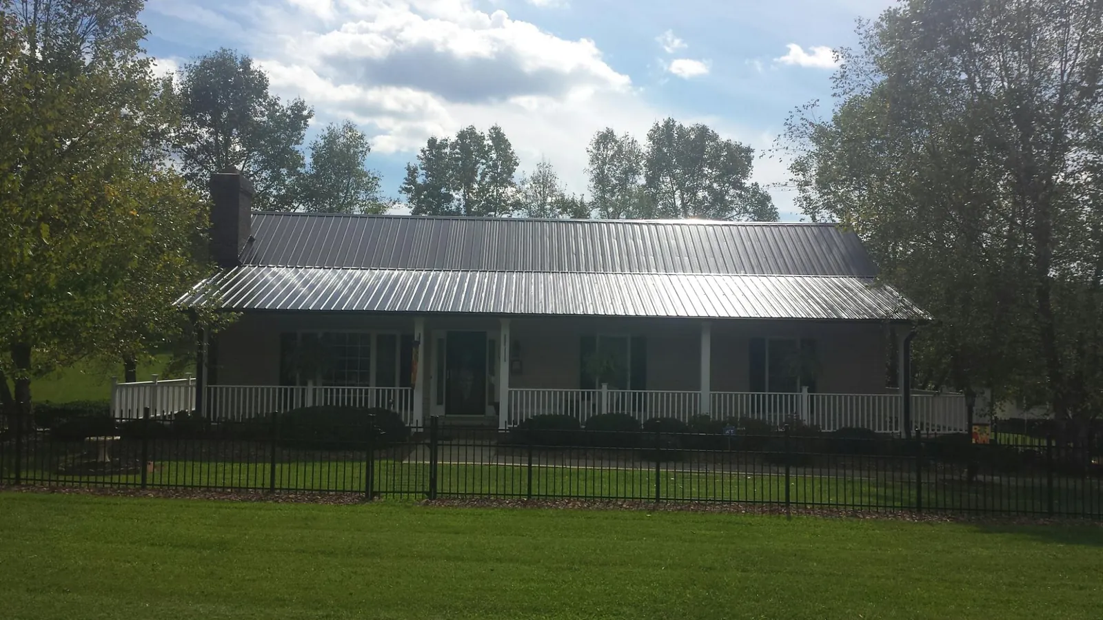 Gray metal roof on a brick ranch with a full width front porch — Gutter Guard Installation work by our crew in Bay Minette