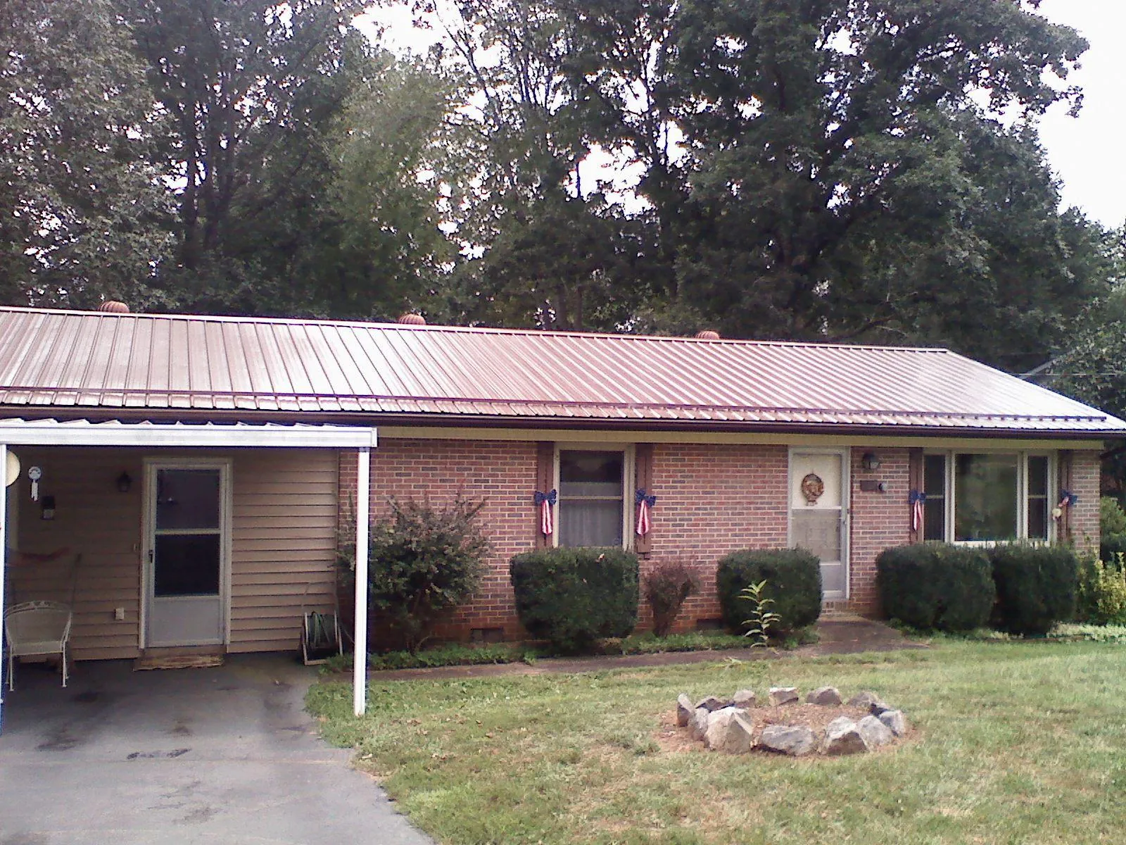 Bronze metal roof and carport on a brick ranch home — Roof Repair work by our crew in Bay Minette