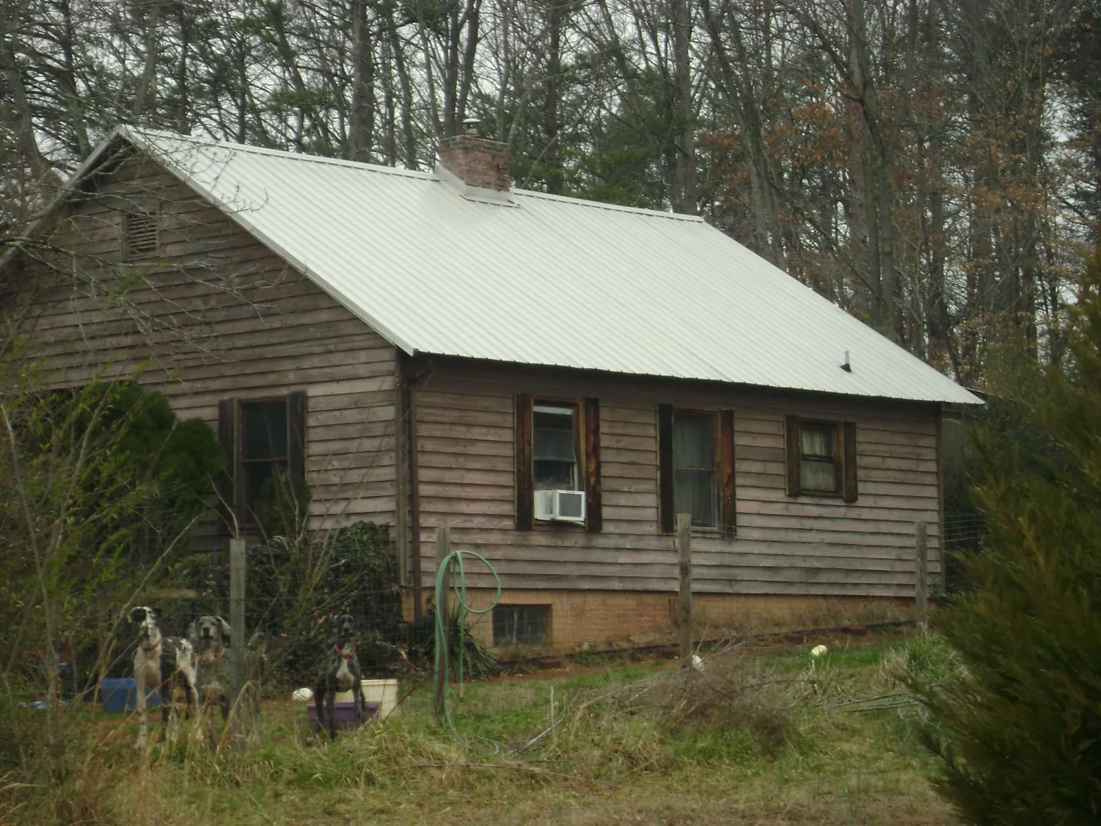 White metal roof on an old wood sided farmhouse, from a Metal Roof Installation job in Bay Minette